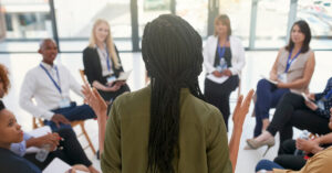 Rearview shot of a young unrecognizable woman delivering a presentation to work colleagues inside a boardroom
