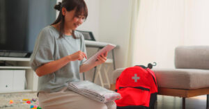 A woman is preparing an emergency bag in the living room at home.