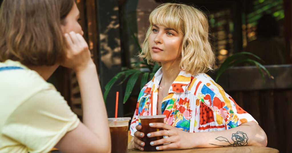 Urban Caucasian female friends having nice time together at the modern coffee shop while talking