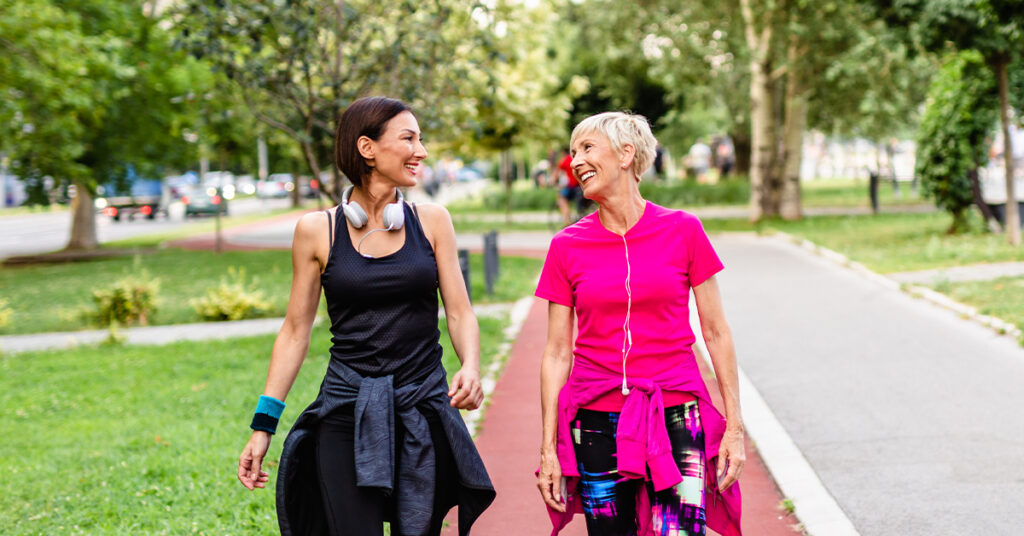 Happy mother and daughter enjoying in walk outdoors in park.