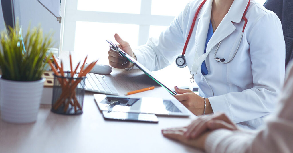 A doctor is talking and examining a patient